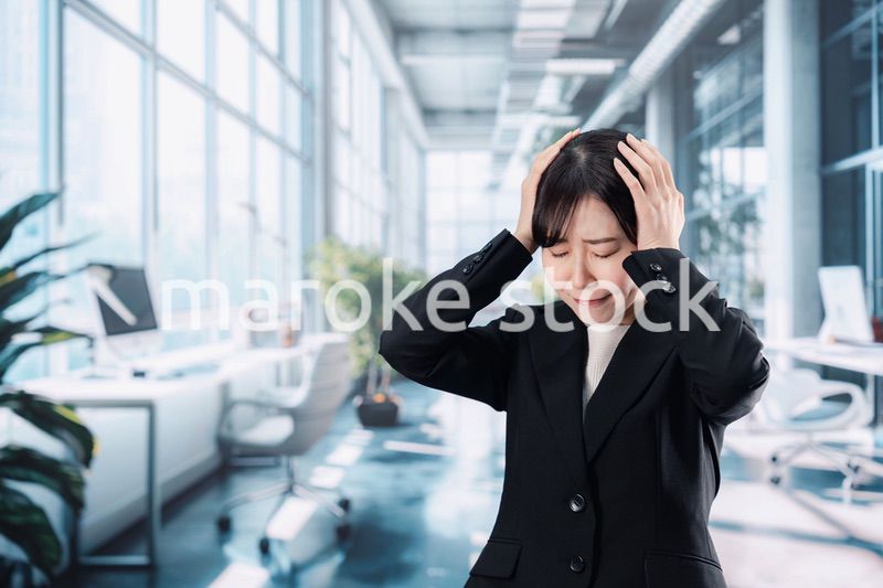オフィスで頭を抱えるビジネスウーマン