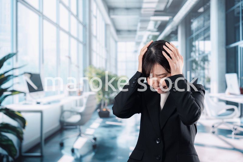 オフィスで頭を抱えるビジネスウーマン