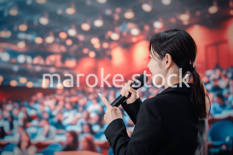 大勢の聴衆の前でスピーチをする女性