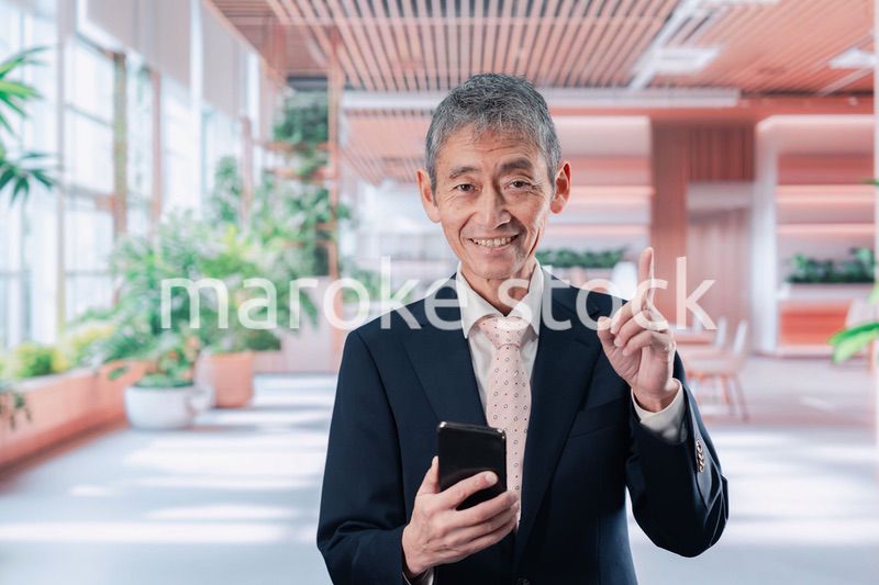 笑顔でスマホを使う中年のビジネスマン