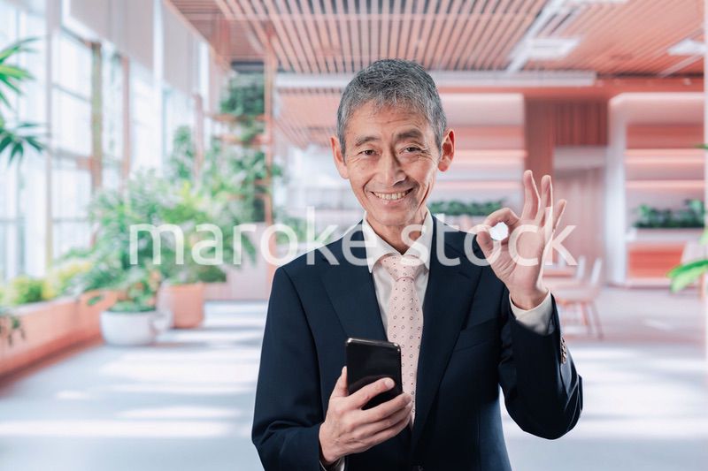 笑顔でスマホを使う中年のビジネスマン