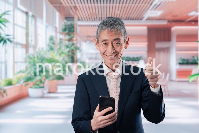 笑顔でスマホを使う中年のビジネスマン