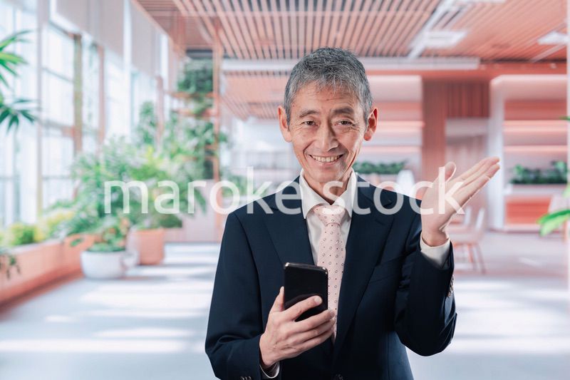 笑顔でスマホを使う中年のビジネスマン