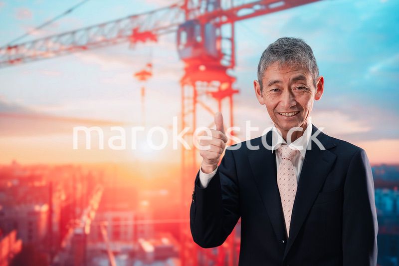 タワークレーンの前に立つスーツ姿の男性ビジネスマン