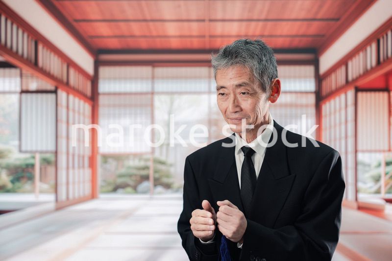 葬儀に参列する高齢の男性