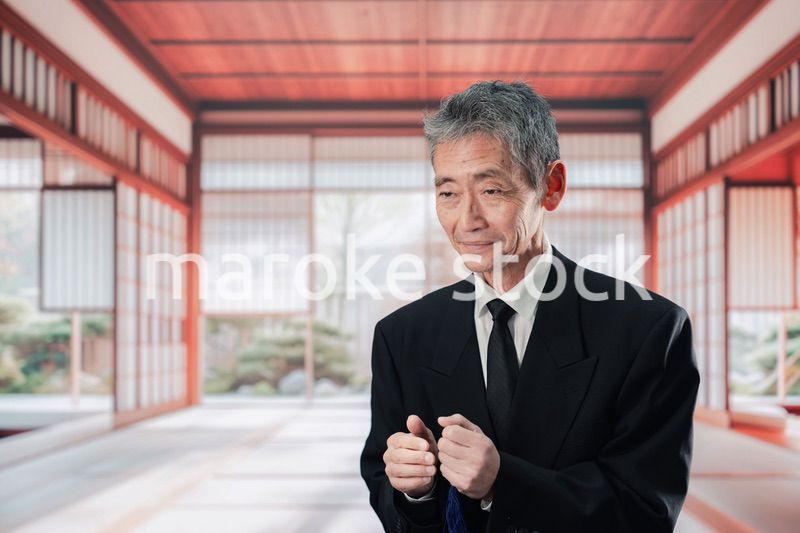 葬儀に参列する高齢の男性