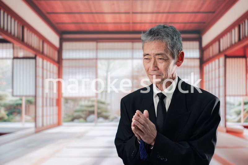 葬儀に参列する高齢の男性