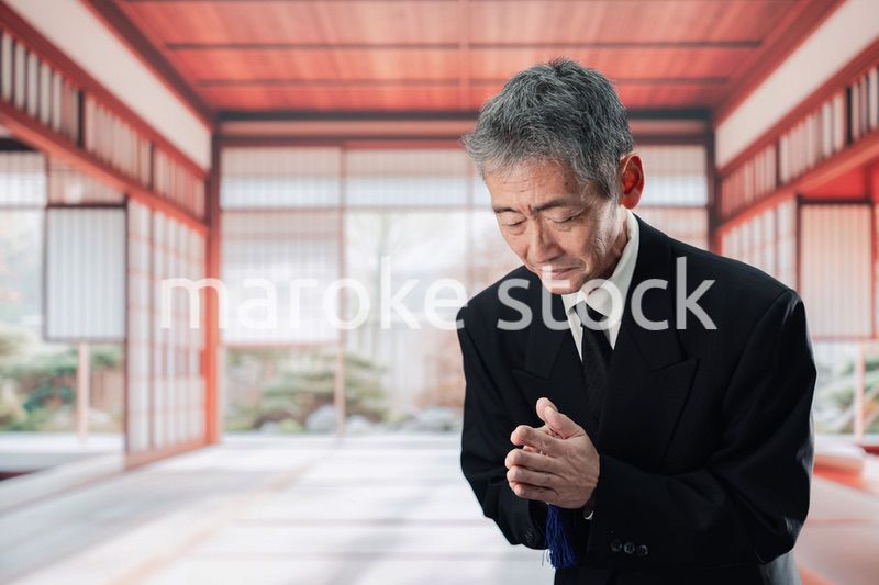 葬儀に参列する高齢の男性