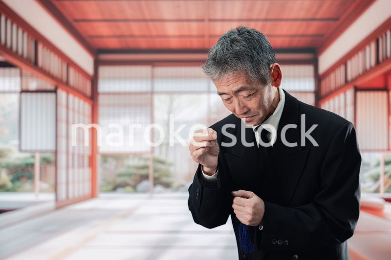 葬儀に参列する高齢の男性