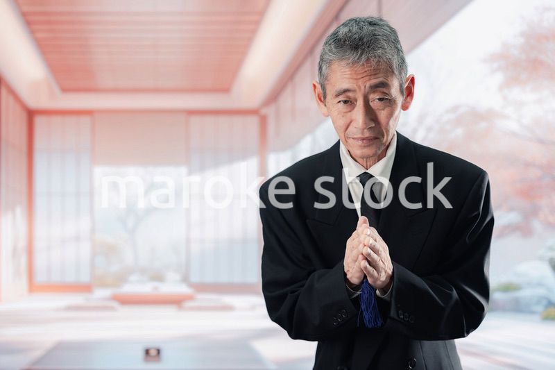 葬儀に参列する高齢の男性