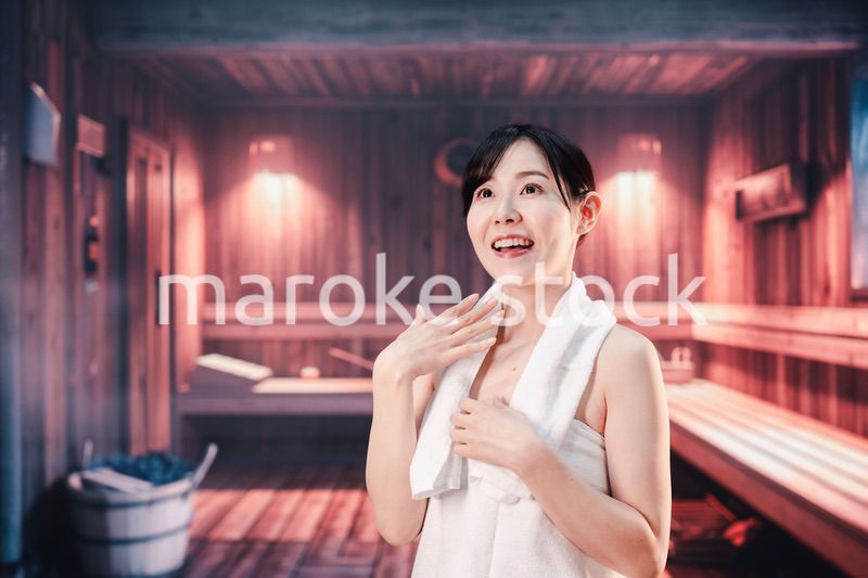 サウナで汗をかく若い女性