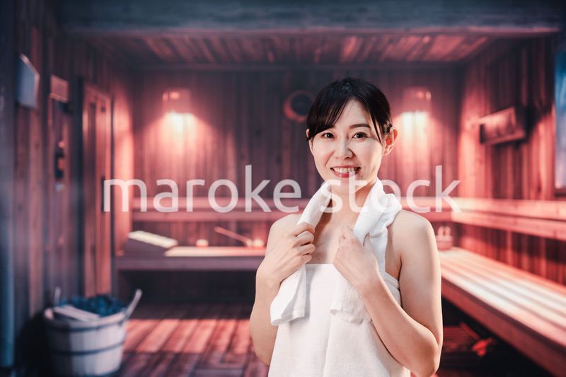 サウナで汗をかく若い女性