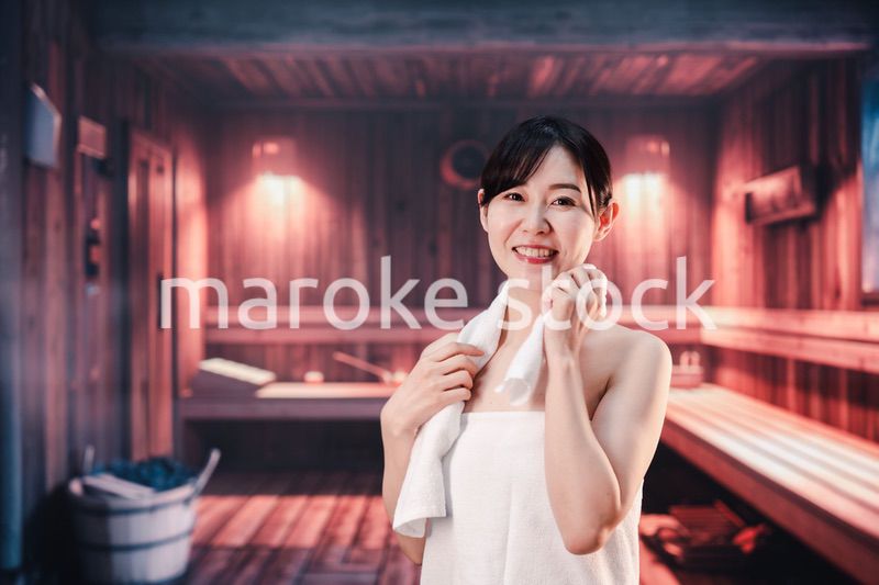 サウナで汗をかく若い女性