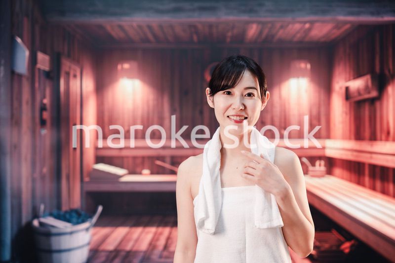 サウナで汗をかく若い女性
