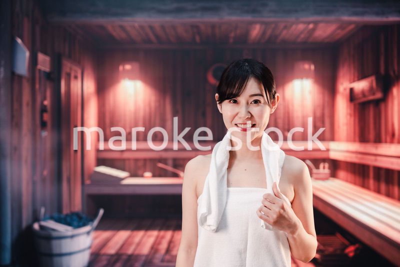 サウナで汗をかく若い女性