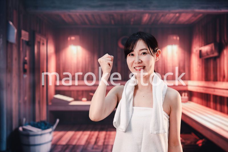 サウナで汗をかく若い女性