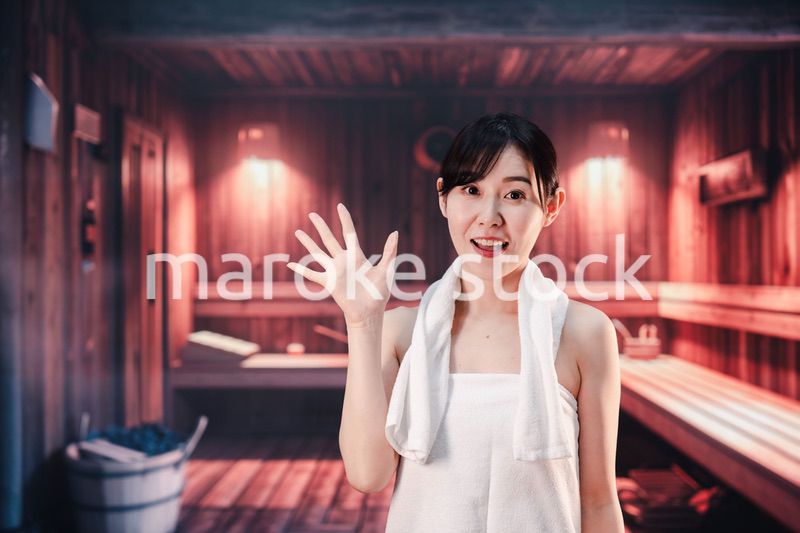 サウナで汗をかく若い女性