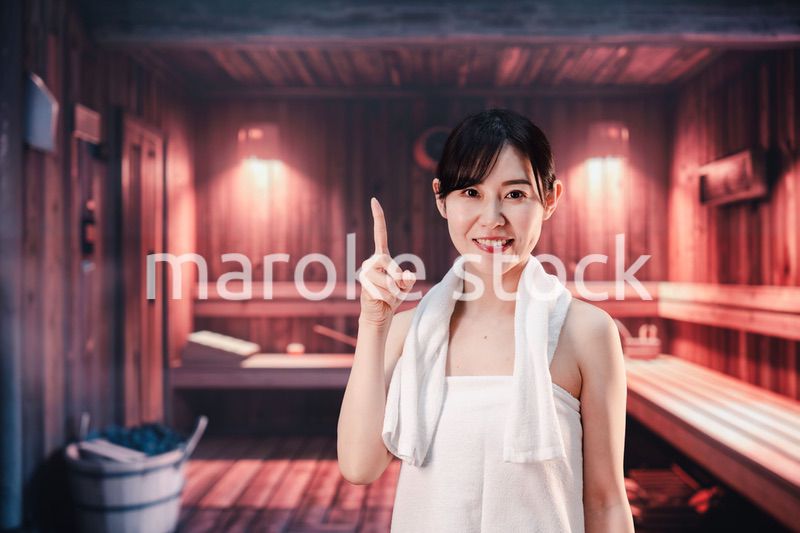 サウナで汗をかく若い女性