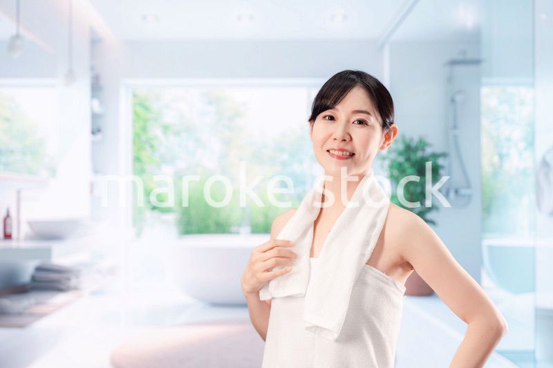 バスルームでボディケアをする若い女性