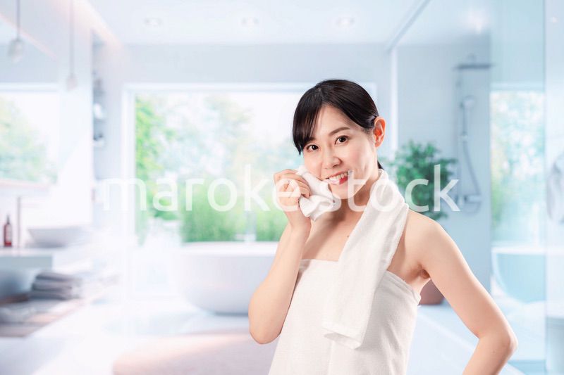 バスルームでボディケアをする若い女性