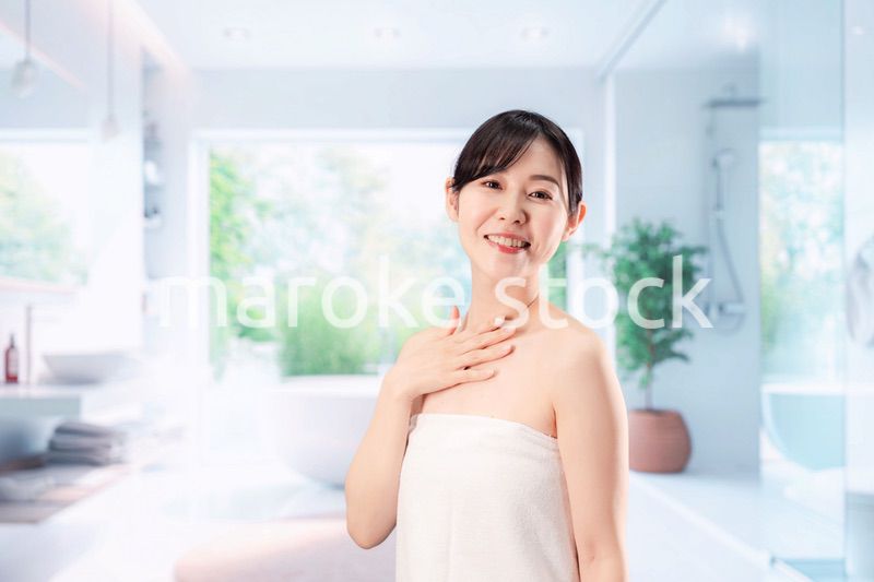 バスルームでボディケアをする若い女性