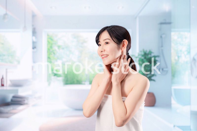 バスルームでボディケアをする若い女性