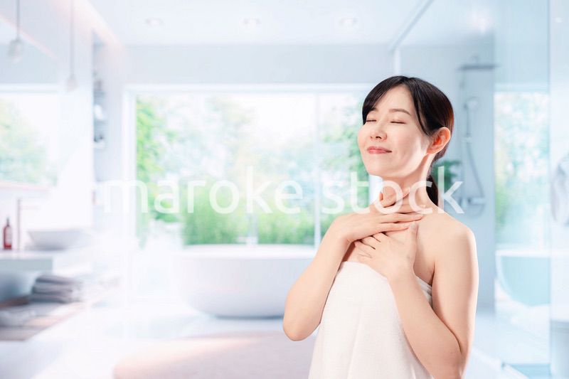 バスルームでボディケアをする若い女性