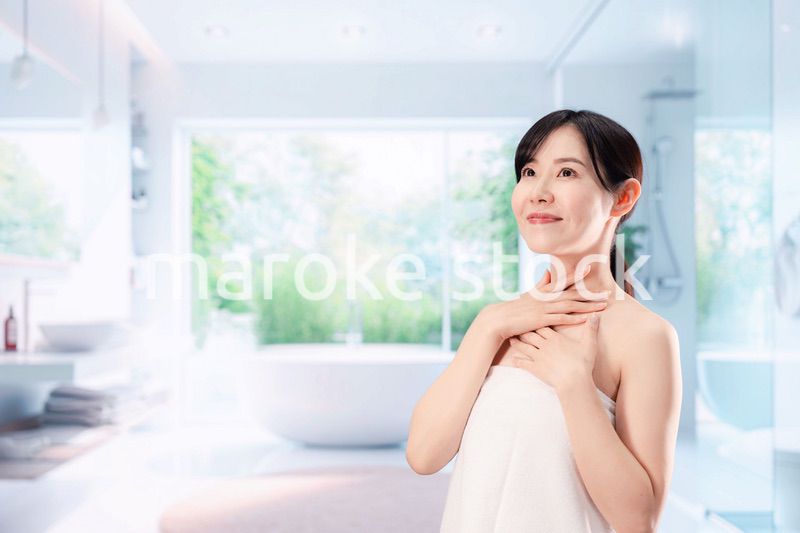 バスルームでボディケアをする若い女性