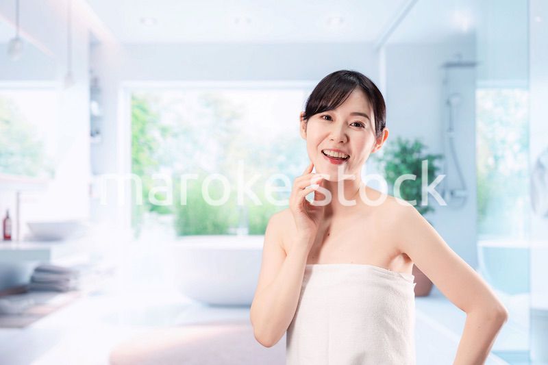 バスルームでボディケアをする若い女性