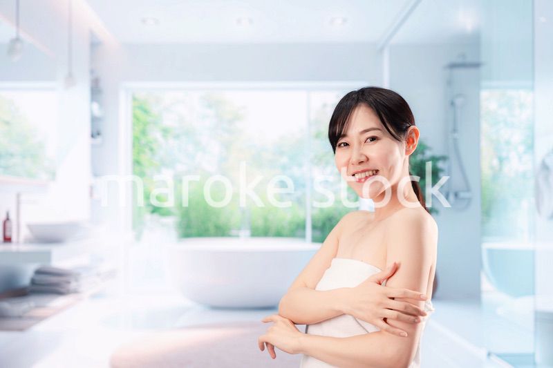 バスルームでボディケアをする若い女性