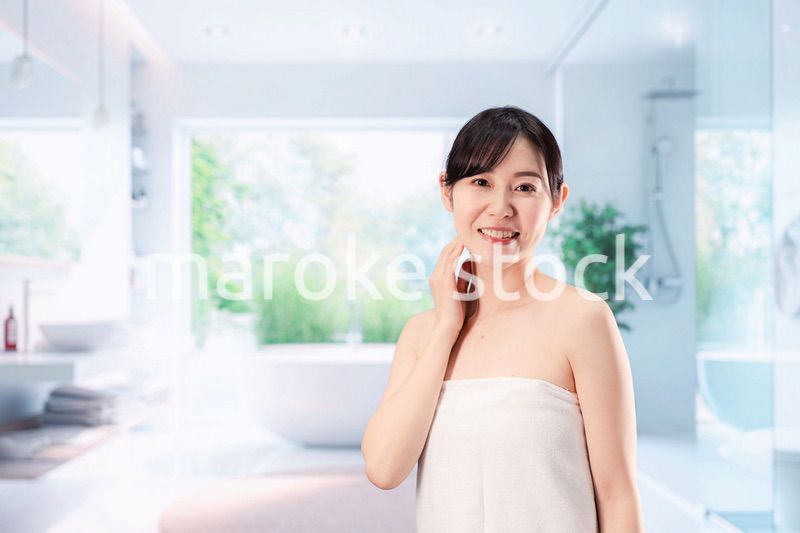 バスルームでボディケアをする若い女性