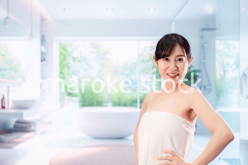 バスルームでボディケアをする若い女性