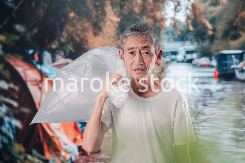 ゴミ拾いをするホームレスの男性