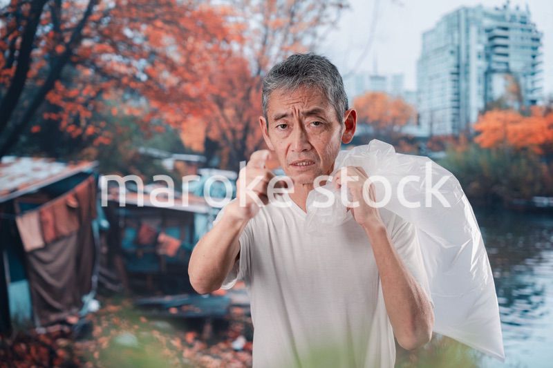 ゴミ拾いをするホームレスの男性