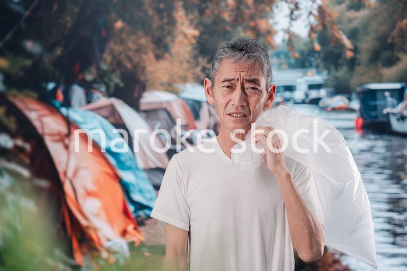 ゴミ拾いをするホームレスの男性