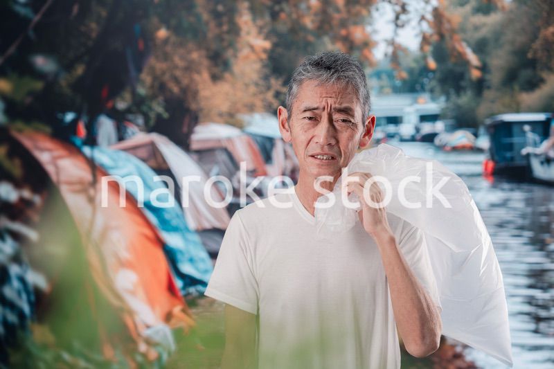 ゴミ拾いをするホームレスの男性