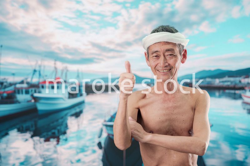 笑顔で腕を組む高齢の漁師