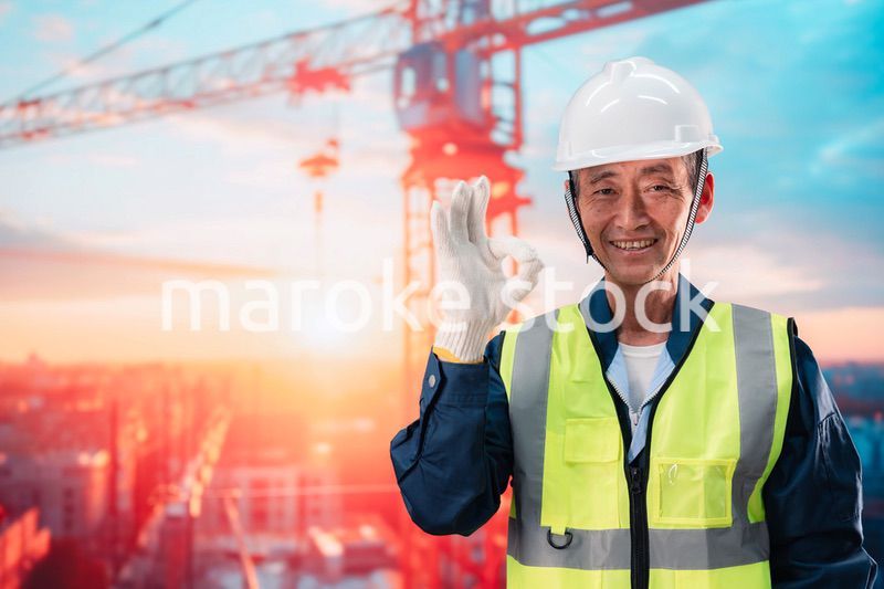 高層ビルの建設現場で監督をする高齢の男性