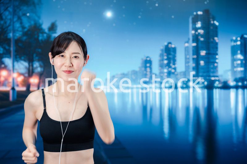 夜の街をランニングする女性