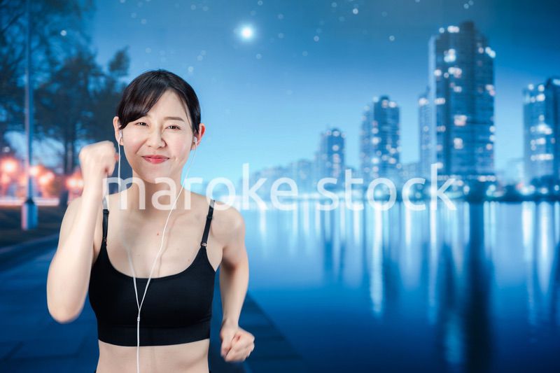 夜の街をランニングする女性