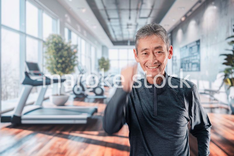 スポーツジムで運動をするシニアの男性