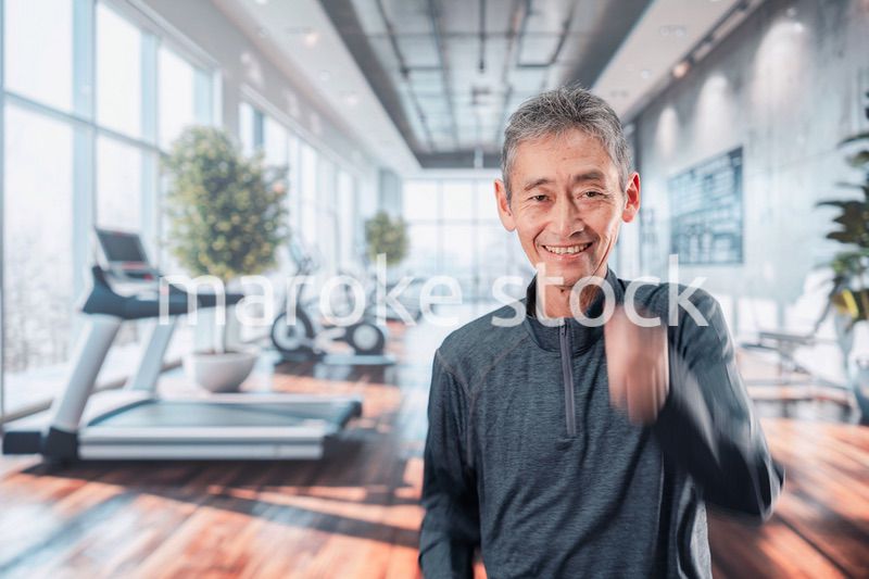 スポーツジムで運動をするシニアの男性