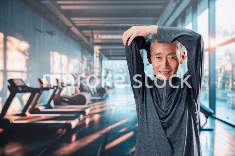 スポーツジムで運動をするシニアの男性