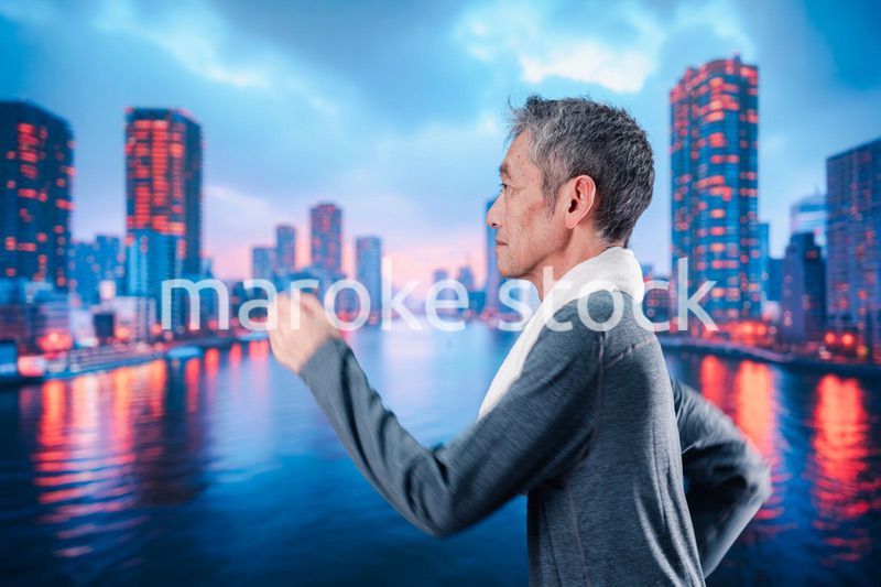 都会をランニングする高齢の男性
