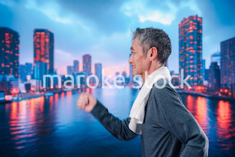 都会をランニングする高齢の男性