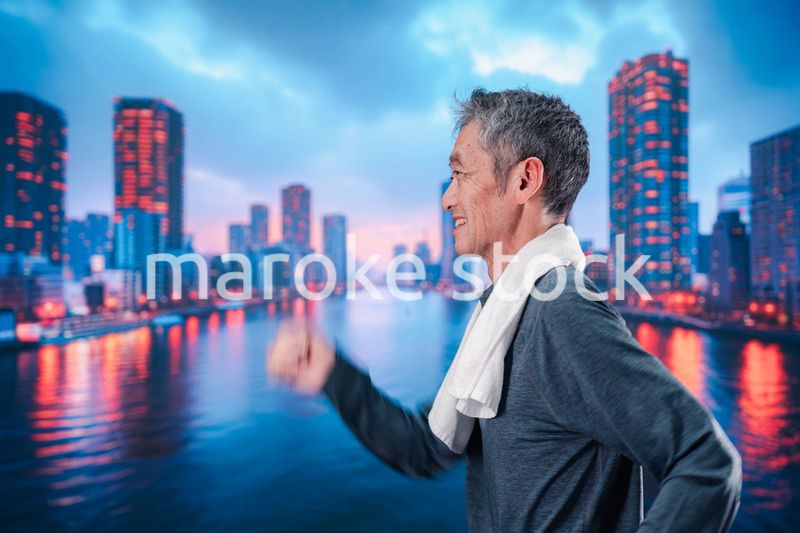 都会をランニングする高齢の男性
