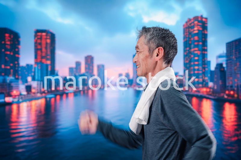 都会をランニングする高齢の男性