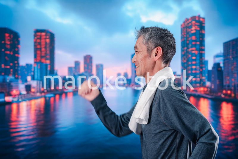 都会をランニングする高齢の男性