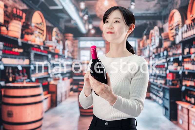 ワインショップでワインを選ぶ若い女性