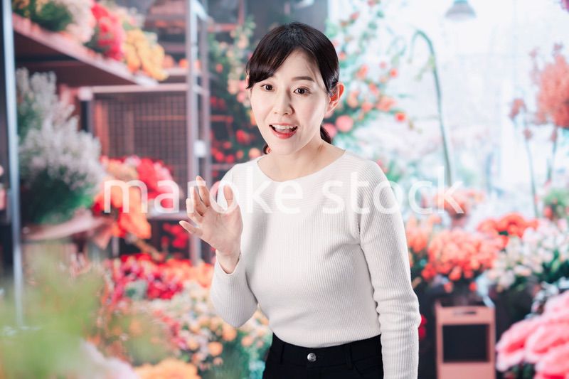 お花屋さんで花を選ぶ若い女性